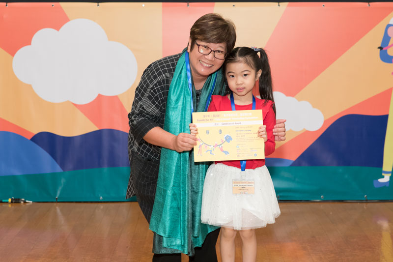 書伴我行（香港）基金會社區閱讀發展總監蔡淑玲女士頒發獎狀予幼兒組入圍者鄒雨桐小朋友。